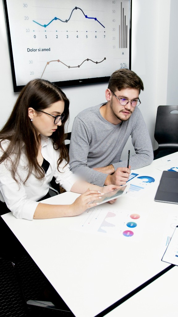 Colleagues reviewing data and delivery plans together at a desk